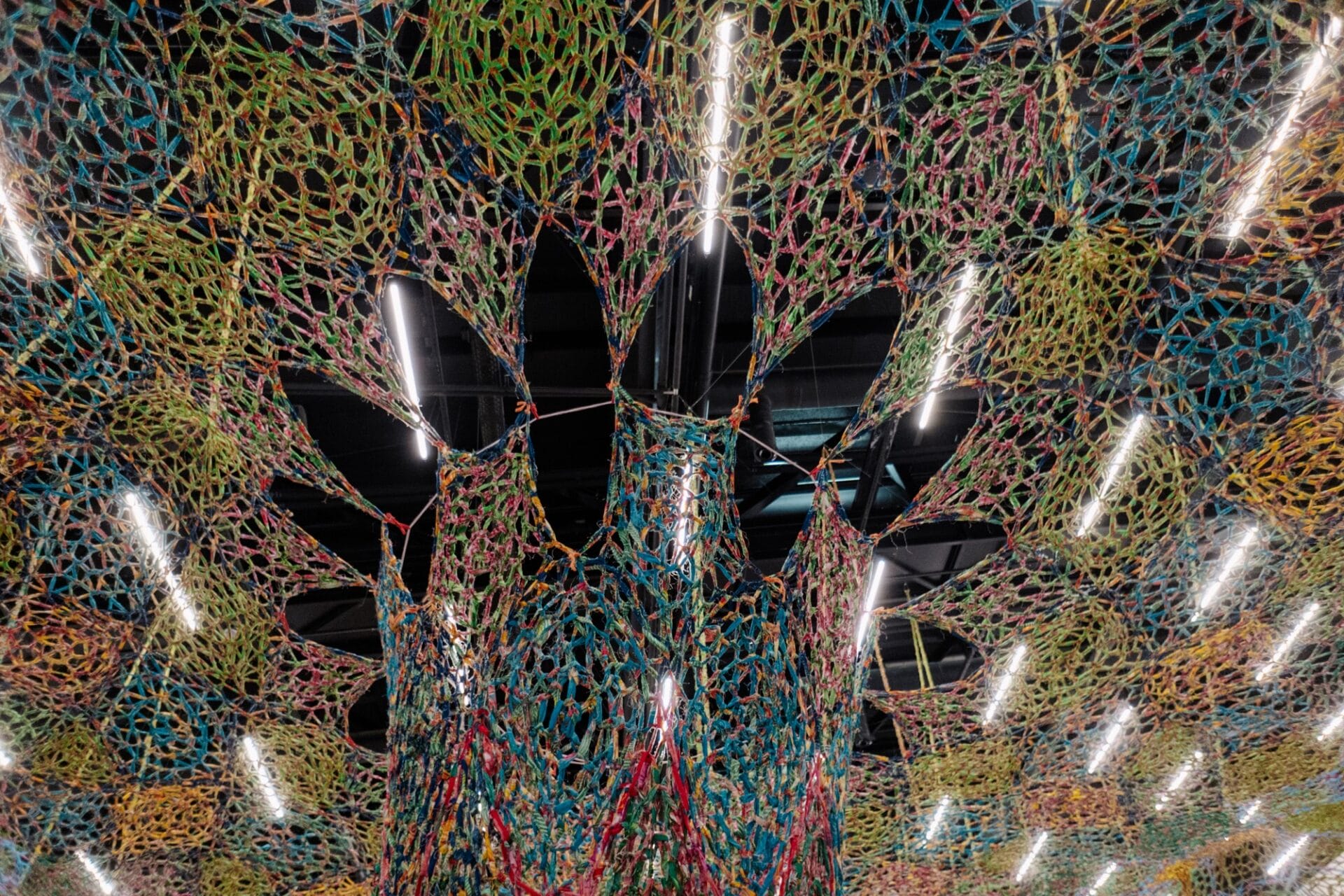 a view looking up at a large crocheted installation