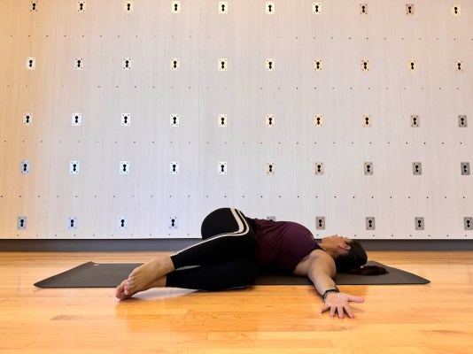 Pilates instructor demonstrating supine spinal twist