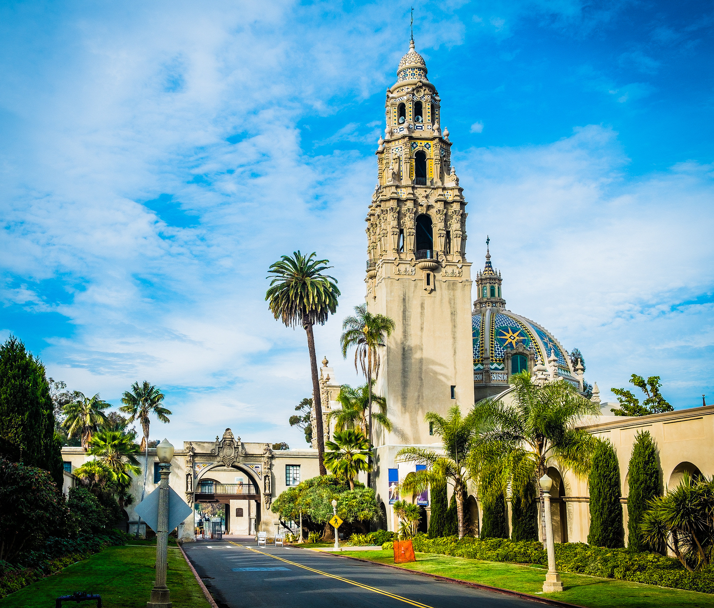 A building with a tall bell tower in landscaped parkland