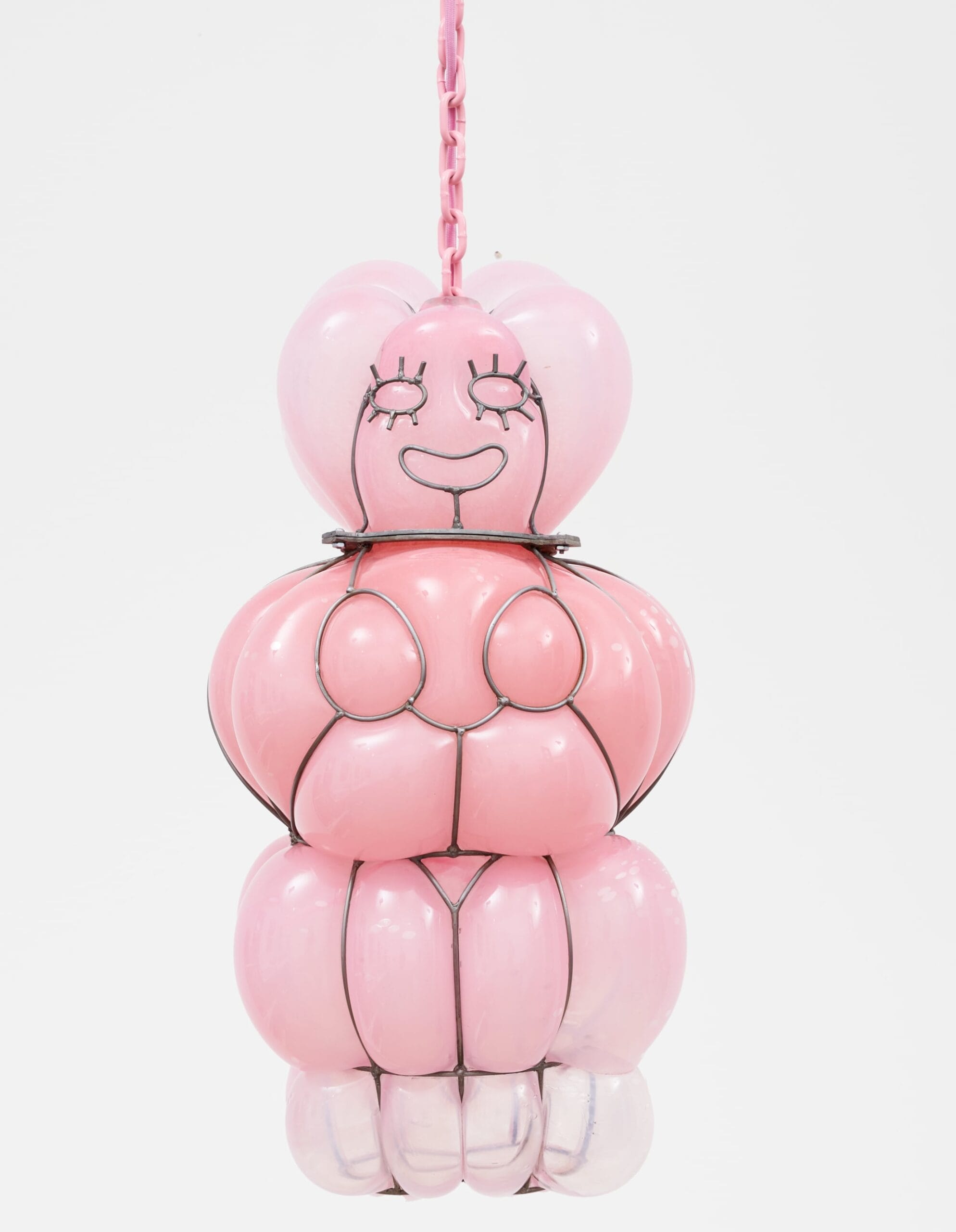 a glass blown pendant lamp hanging from a chain that bubbles inside steel armature and appears like a pink smiling venus