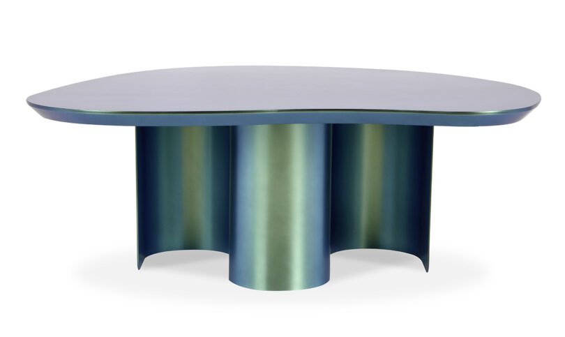 A modern iridescent table with an irregularly shaped top and cylindrical legs.