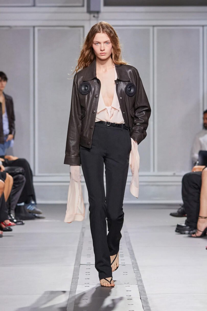 Black leather Coperni x Transparent Speaker Jacket as worn by a model walking the runway during Paris Fashion Week 2024.