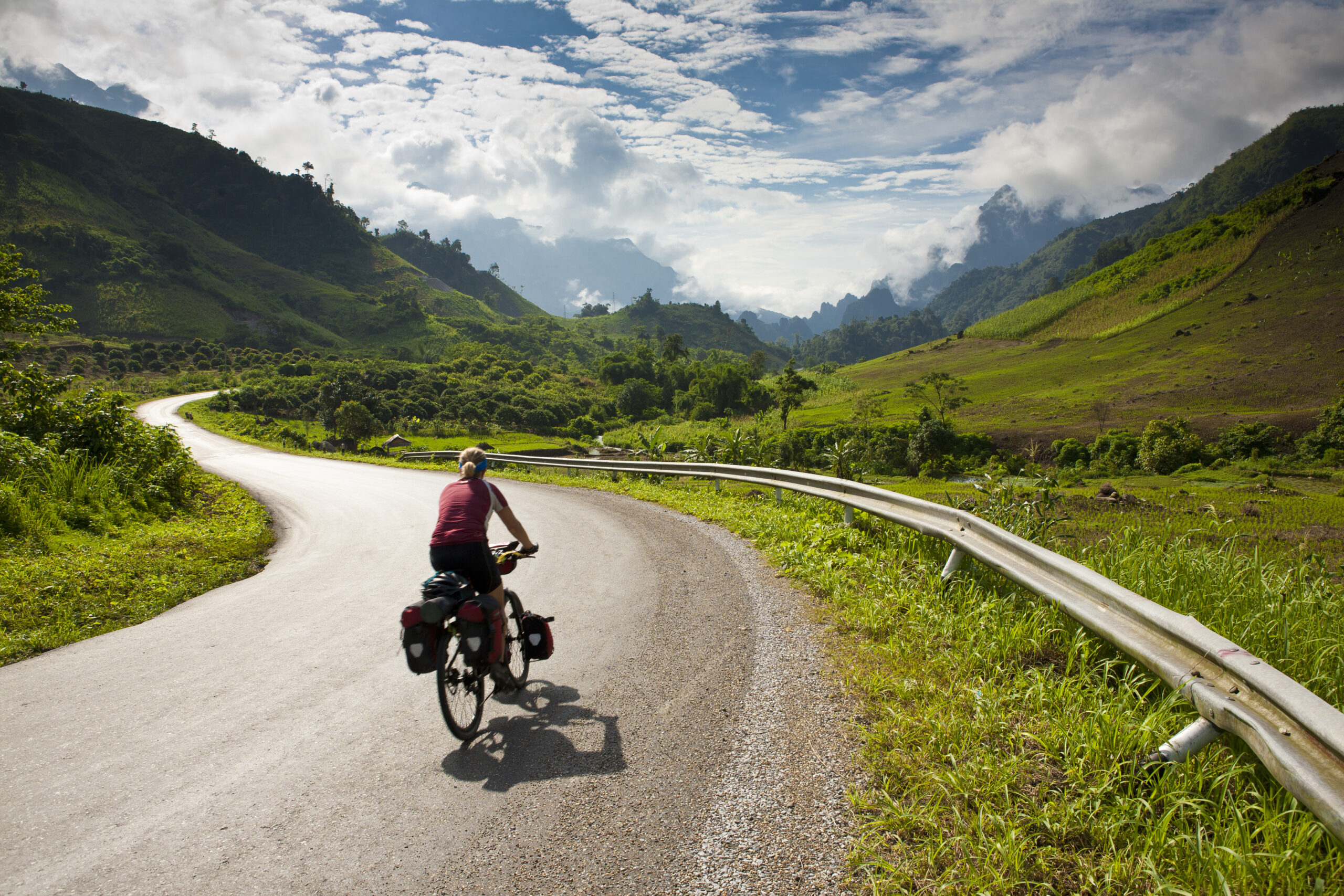 GettyRF146661870.jpg Cyclist riding on a road in Laos