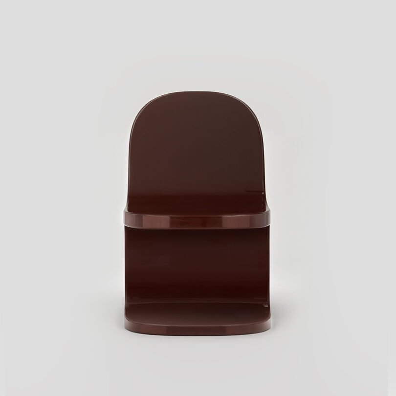 Brown modern chair against a neutral gray background.