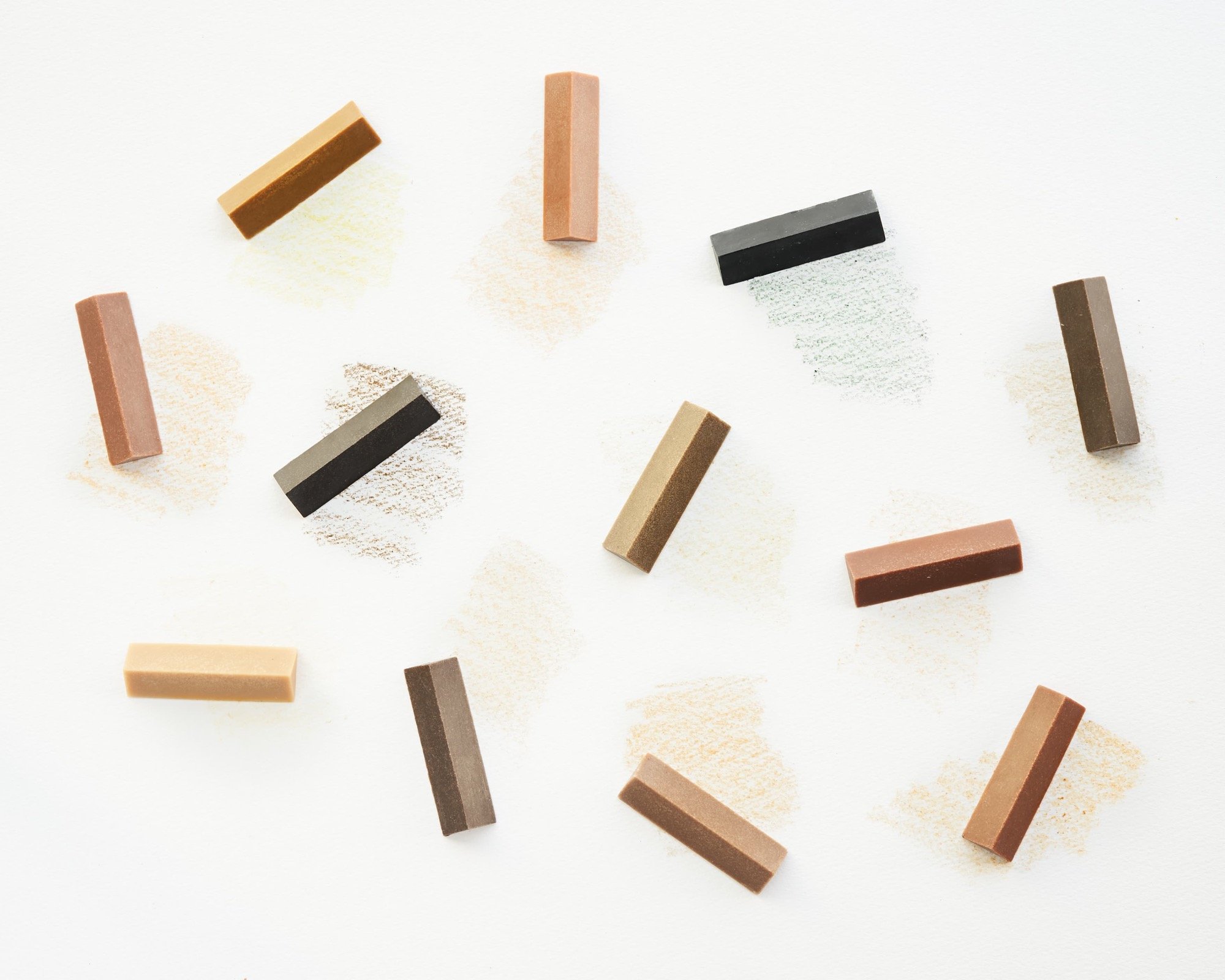 an array of colorful, triangular crayons made from the naturally occurring colors of wood from different trees