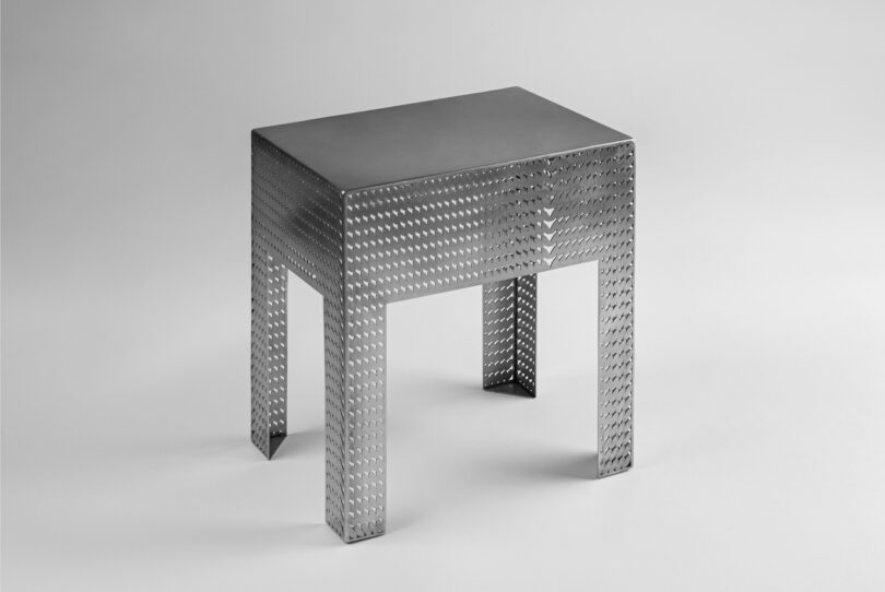 stainless steel metal stool on a grey background