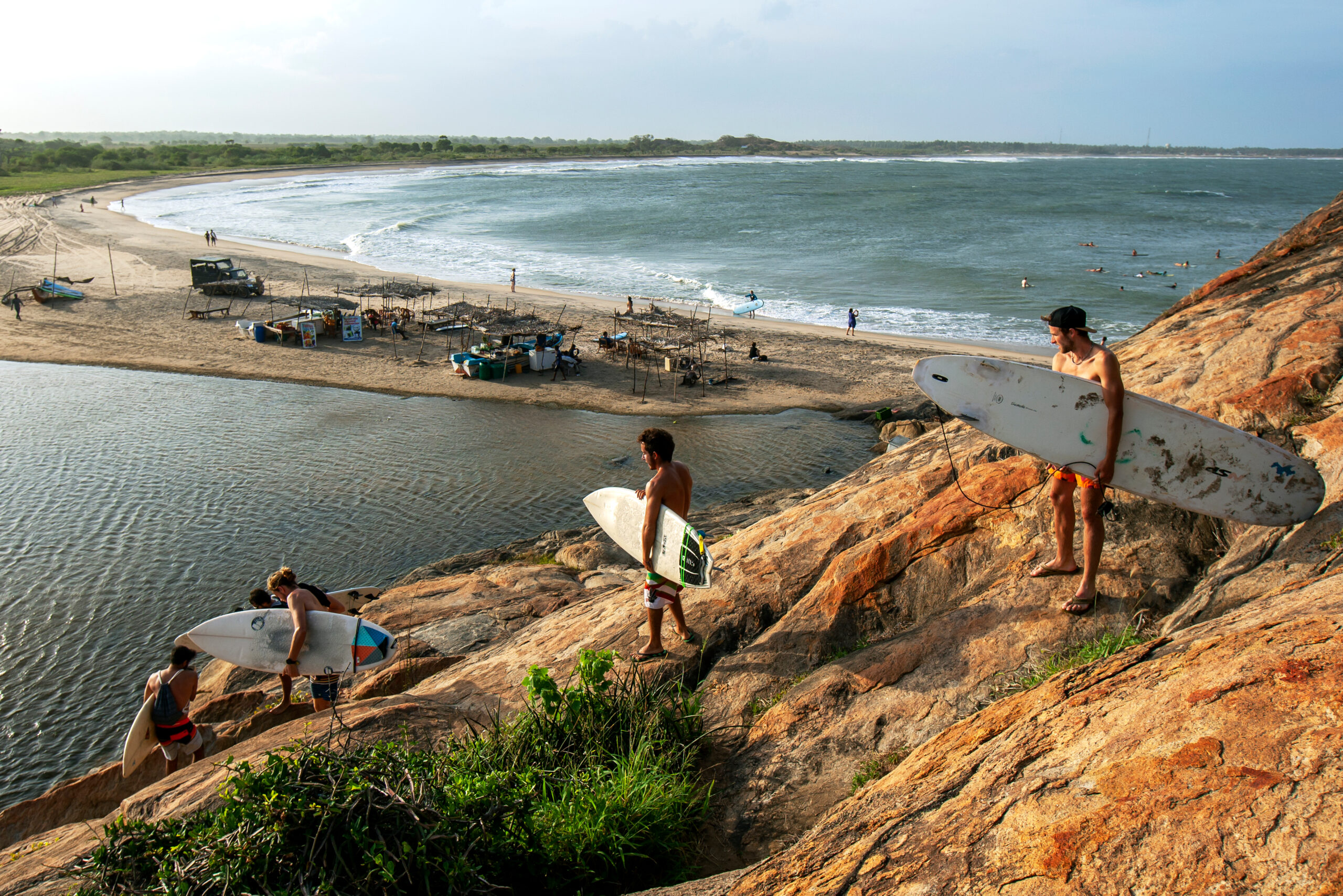 shutterstock1492815632.jpg Young surfers carrying their boards to the beach in Sri Lanka