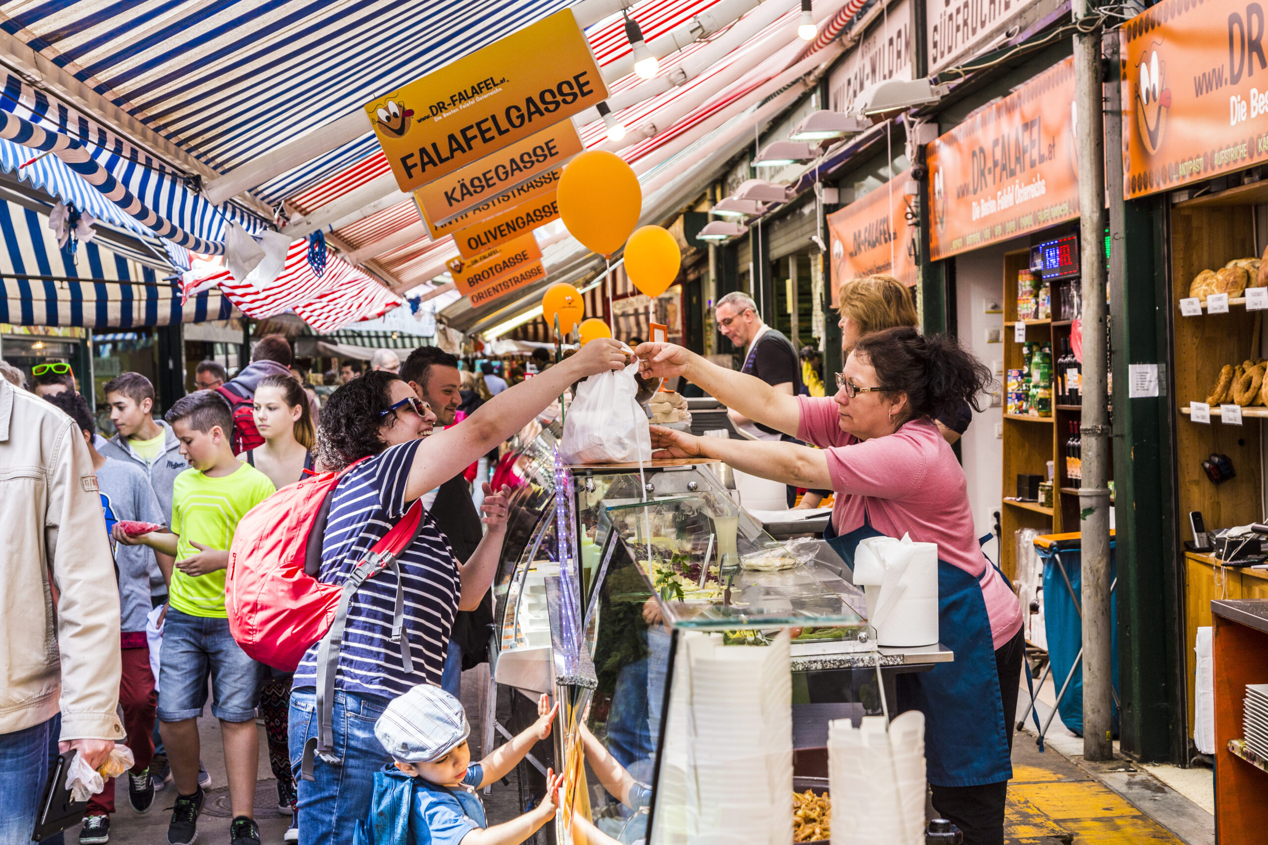 People at the stalls buying food at Naschmarket in Vienna, Austria