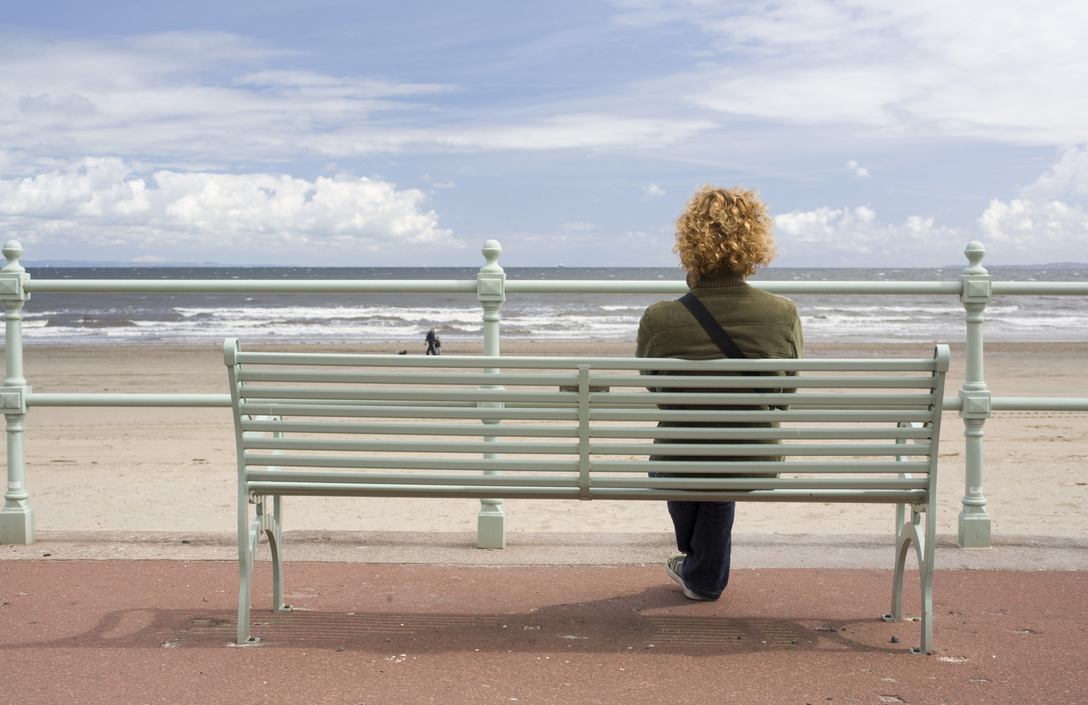 Edinburgh's beaches have a soul-soothing magic, whatever the weather. A woman sitting at a beach on the seafront near Edinburgh.