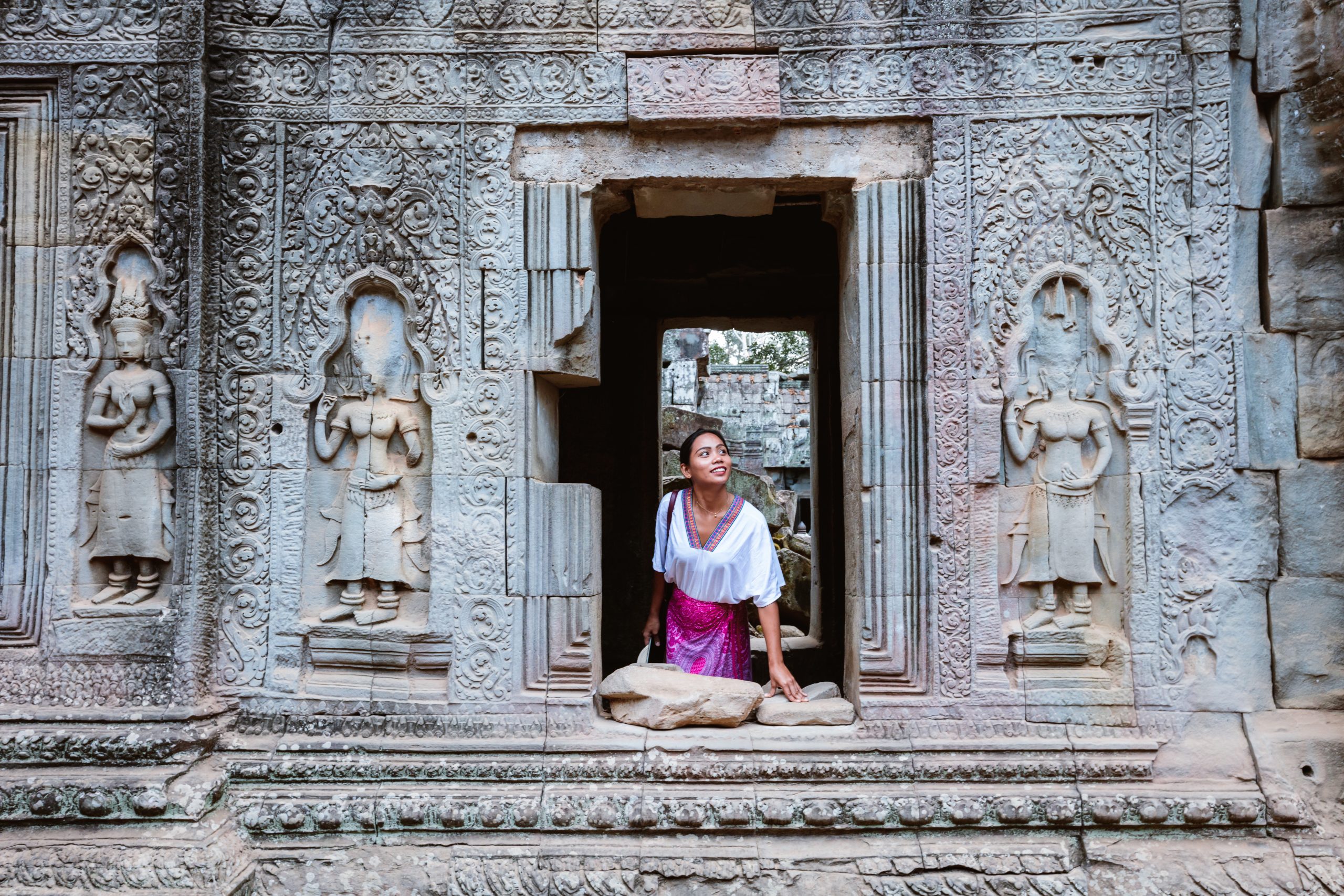 Angkor Wat, Cambodia Woman looking out of a window in a temple, Angkor, Cambodia