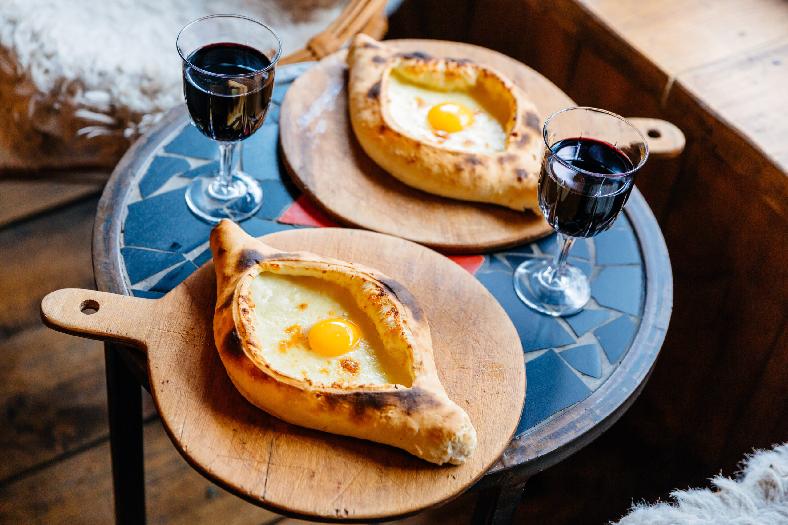A table with Khachapuri and red wine in Tbilisi, Georgia. 