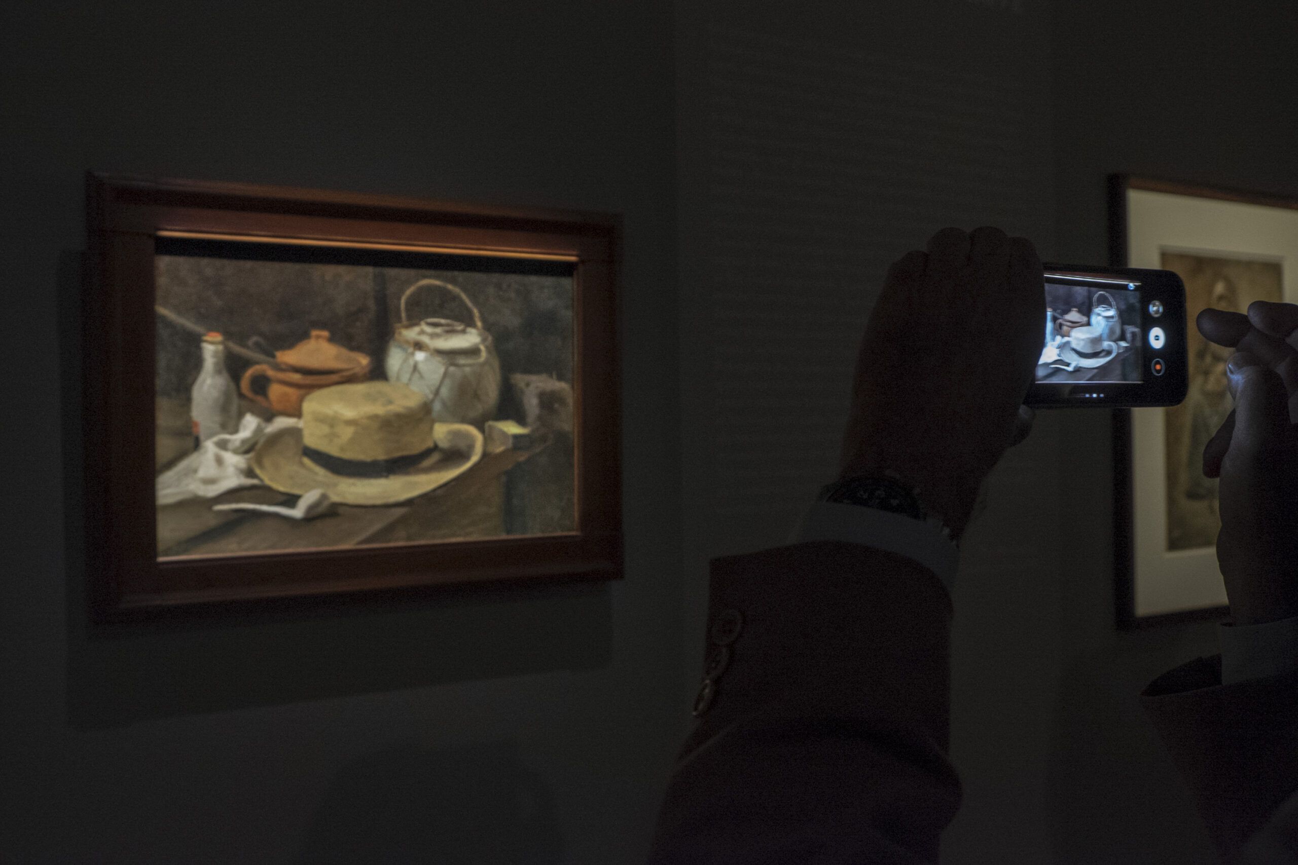 Press Preview of Van Gogh Exhibition In Verona A visitors takes a photo of Van Gogh's painting Still Life with Yellow Straw Hat which hangs in the Kroller-Muller Museum in the Netherlands