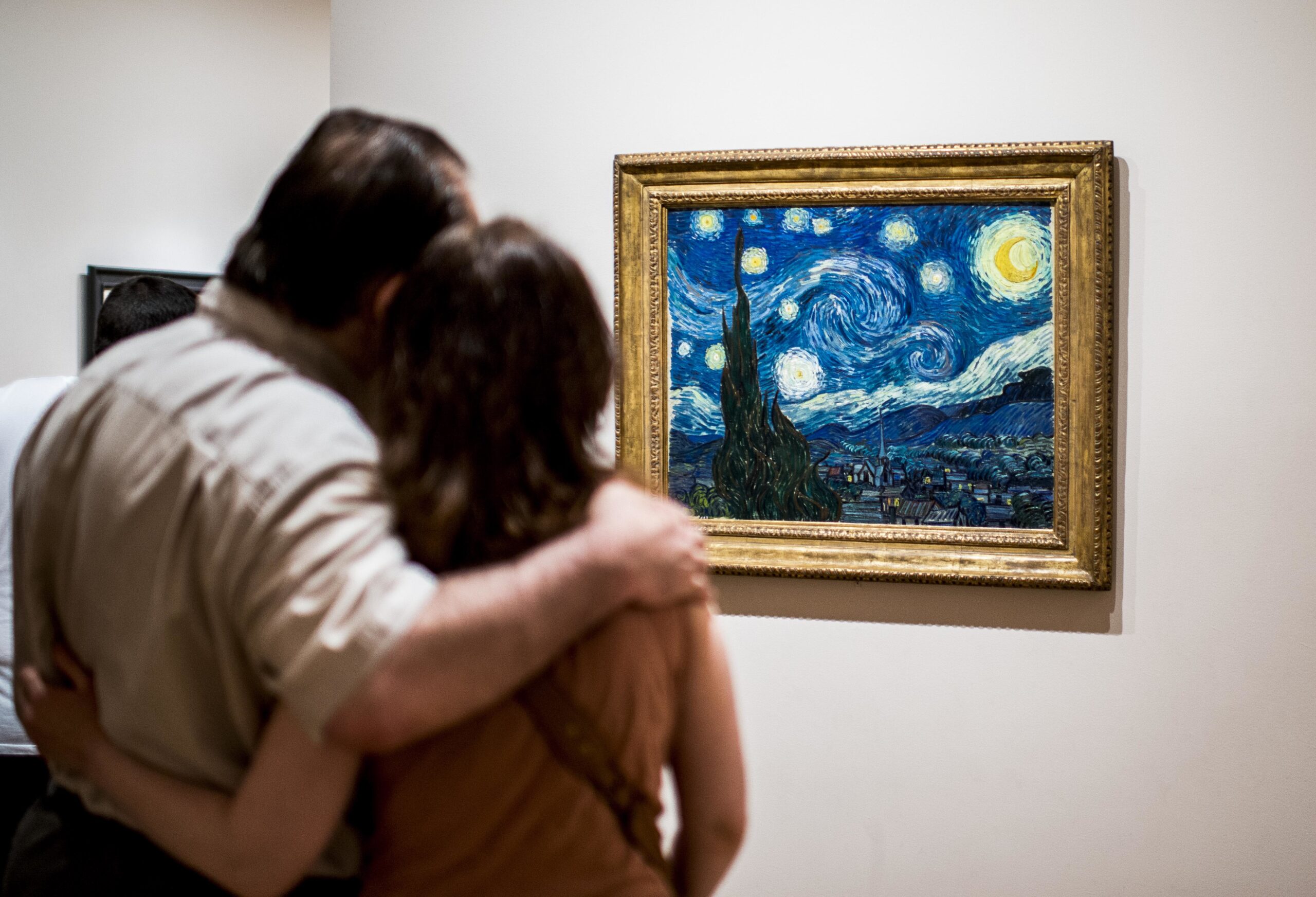 Features of New York - New York City - USA Two tourists, one with their arm around the other, look at The Starry Night by painter Van Gogh at Museum of Modern Art (MoMA), New York.